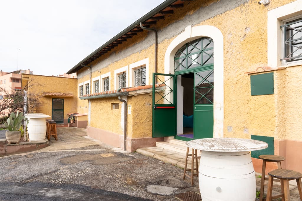 La facciata gialla della Digital Farm con il portone verde ad arco e la corte