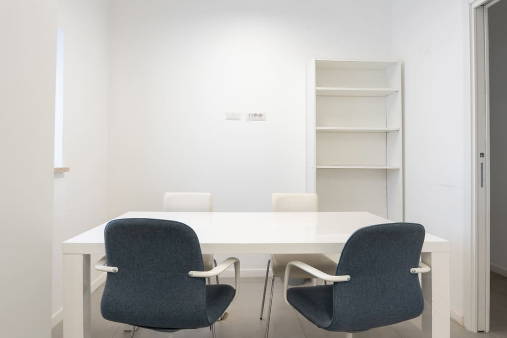 Sala riservata con tavolo bianco e sedute blu